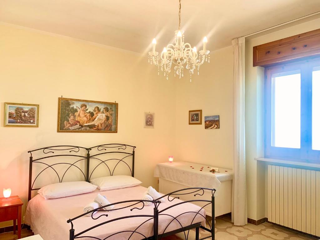 Schlafzimmer mit einem Bett und einem Kronleuchter in der Unterkunft Bed & Breakfast Acquamarina in Castro di Lecce