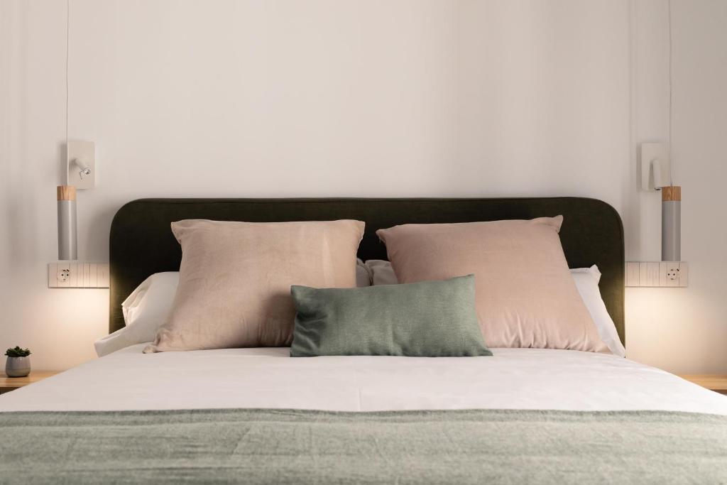 un grande letto con lenzuola e cuscini bianchi di Luxury accomodations with coworking in Grazalema a Grazalema
