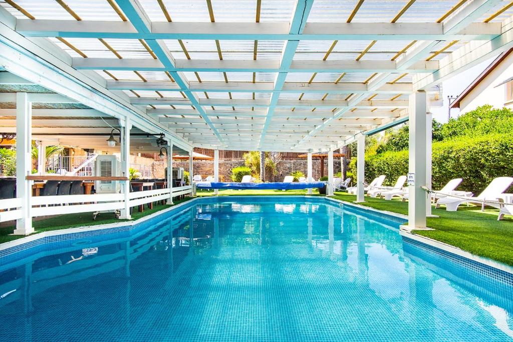 an indoor swimming pool with a pergola and a swimming poolvisor at Nof glili Mansion in Yavneʼel