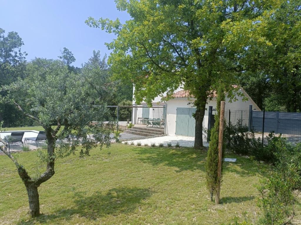a yard with two trees in front of a house at Villa des Mattes - Superbe maison de famille 15 couchages in Crillon-le-Brave
