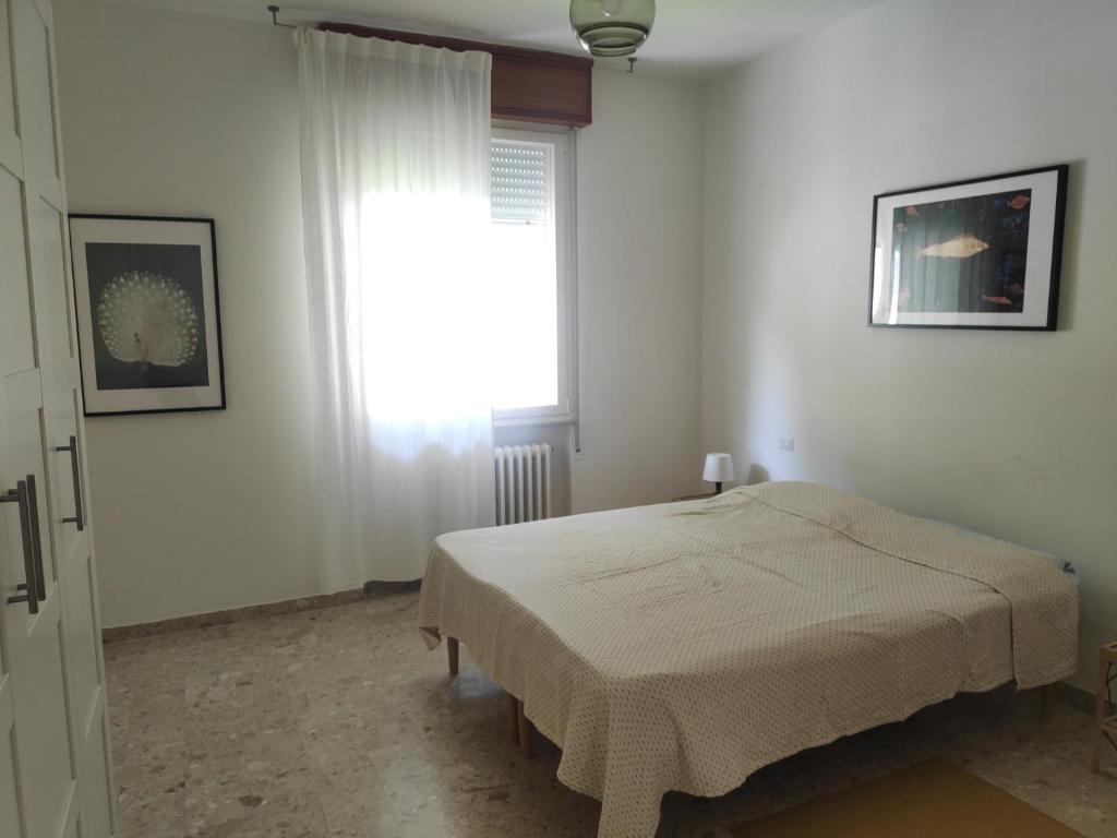 a bedroom with a bed and a window at Appartamento Panoramica in Pesaro
