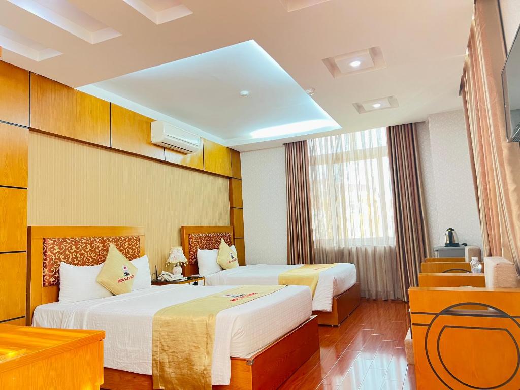 um quarto de hotel com duas camas num quarto em Khách sạn INCO 515.9 em Phủ Lý