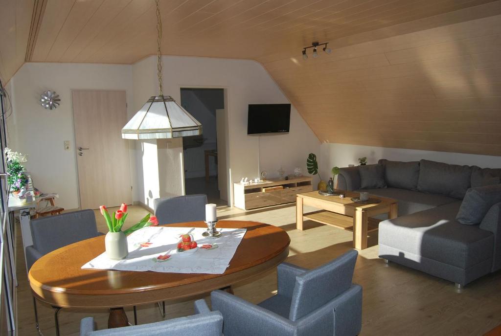 a living room with a couch and a table and chairs at NEU! Schönes Urlaubsdomizil an der Nordsee in Stedesdorf