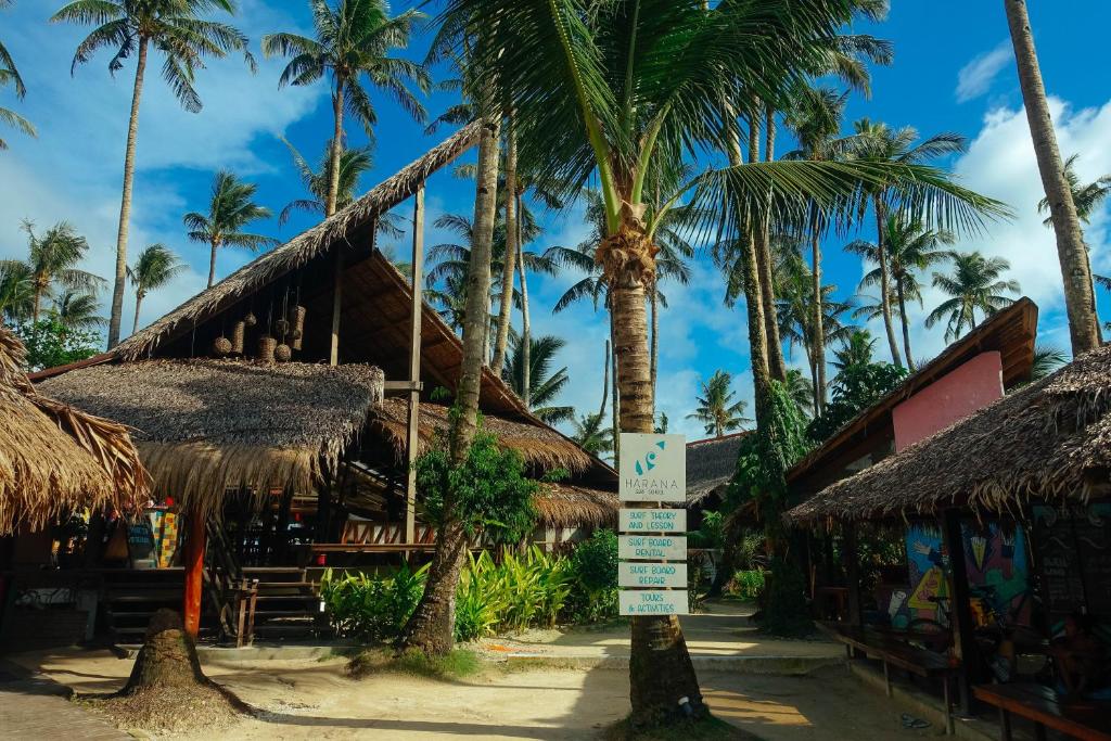 un letrero de la calle frente a un complejo con palmeras en Harana Surf Resort, en General Luna