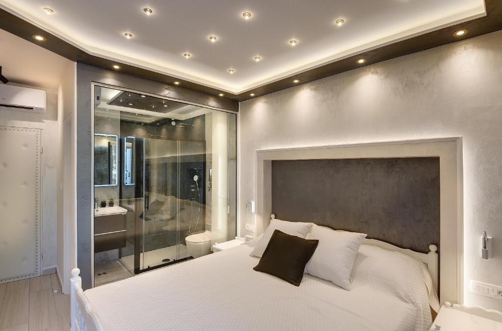 1 dormitorio con 1 cama blanca grande y baño en Apartments Zanetti, en Pula