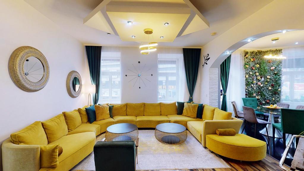 a living room with a yellow couch and tables at Apartment Bilici GmbH in Vienna