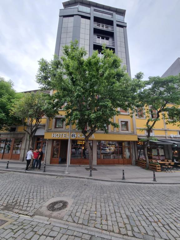 a building with a tree in the middle of a street at Hotel Kalfa in Trabzon