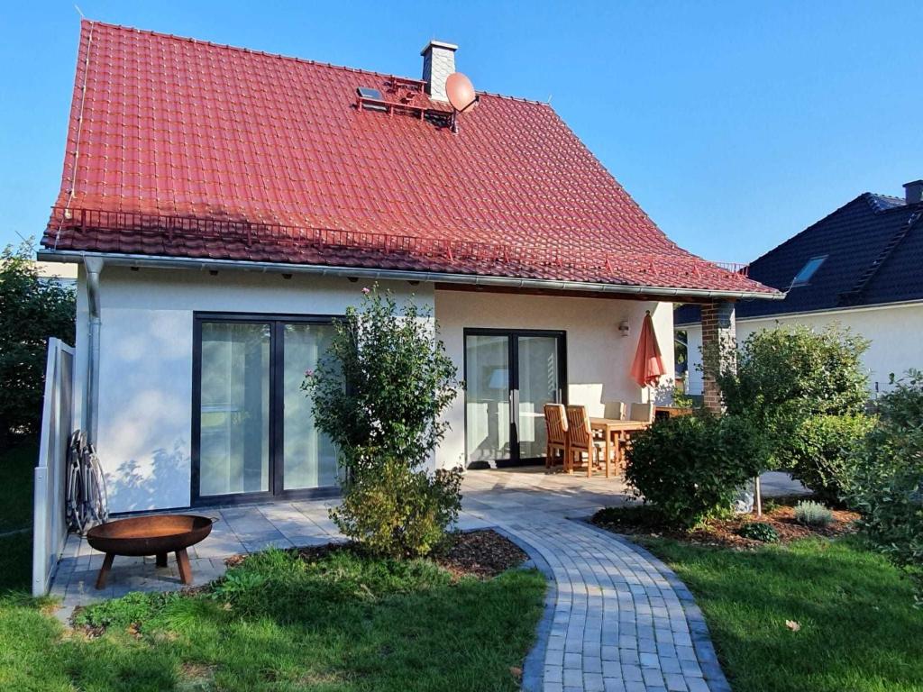 une maison avec un toit rouge et une terrasse dans l'établissement Ferienhaus Spreedeich, à Werben