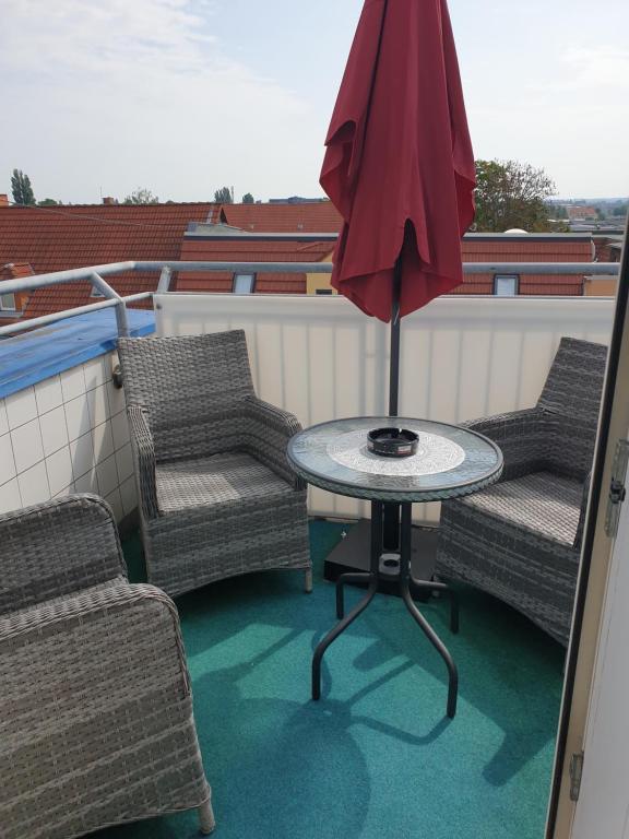 a patio with two chairs and a table and an umbrella at Dachgeschoss Apartment mit Ausblick in Halle an der Saale