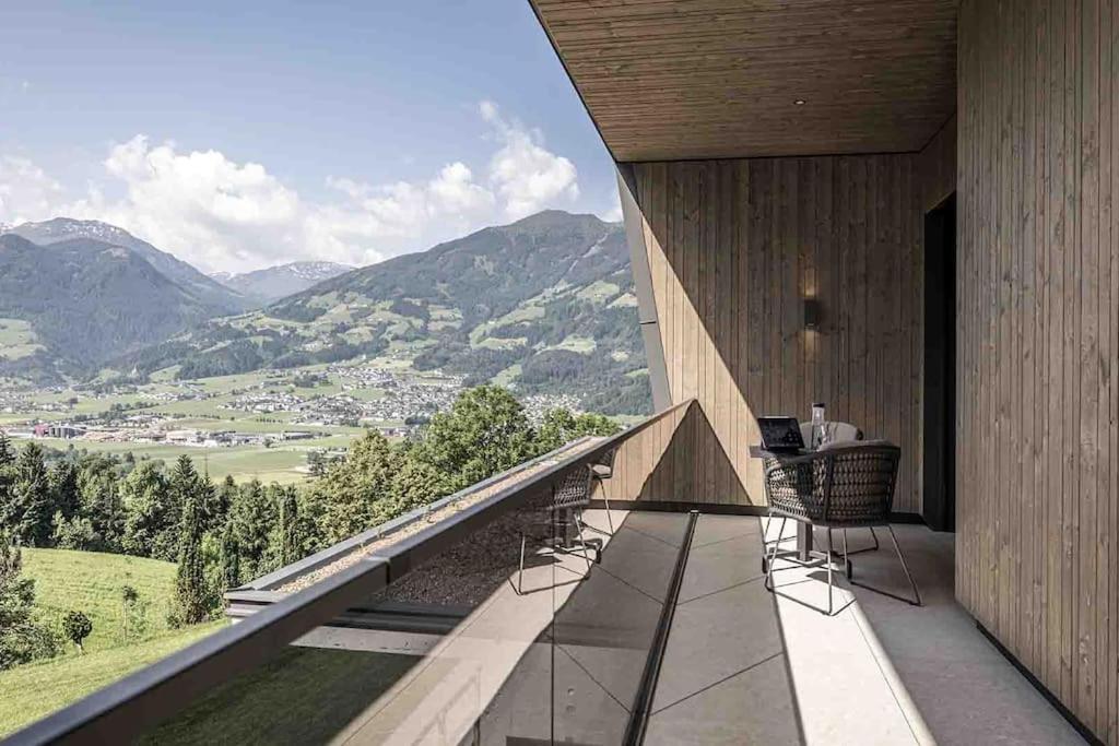 a balcony with a table and chairs and mountains at Panorama Nature Lodge in Hart im Zillertal