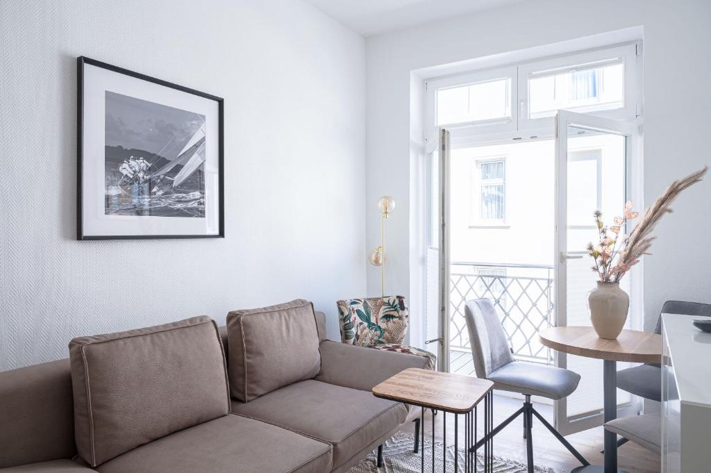 uma sala de estar com um sofá e uma mesa em JOHOUSE Apartment 9 em Warnemünde