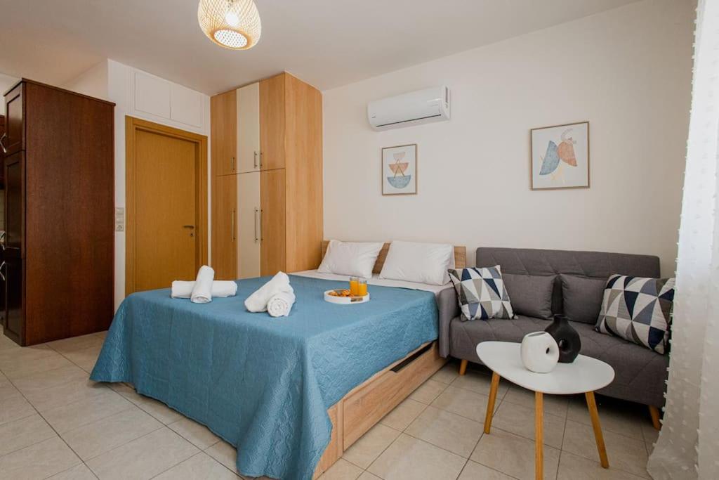 een woonkamer met een bed en een bank bij Oasis Home Heraklion in Heraklion