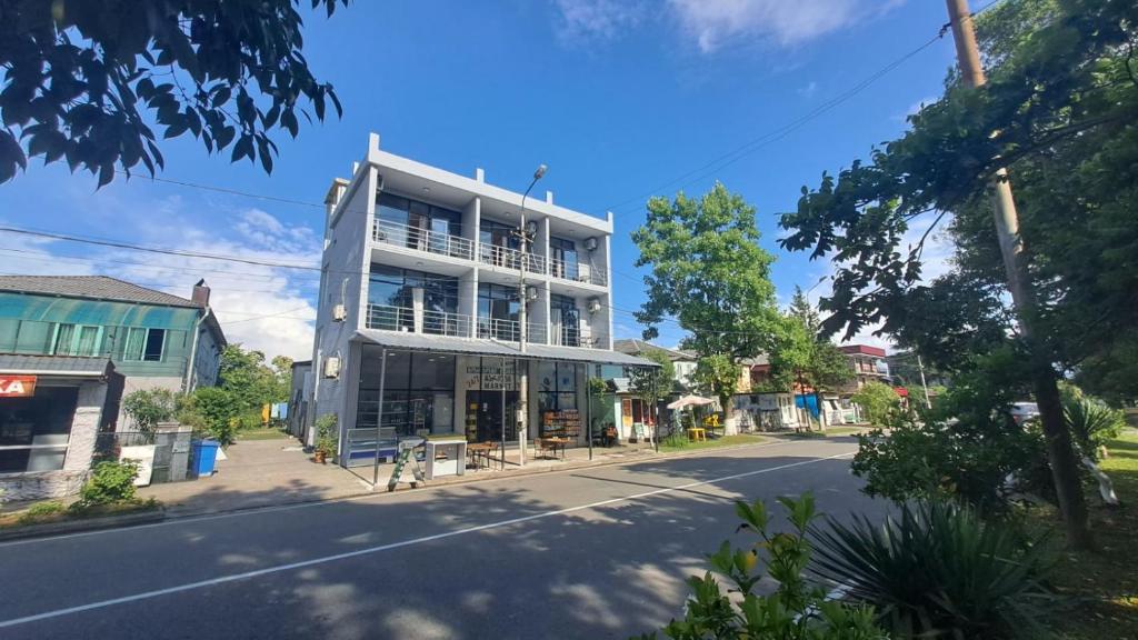 un grand bâtiment blanc sur le côté d'une rue dans l'établissement Hotel Golden beach, à Kobuleti