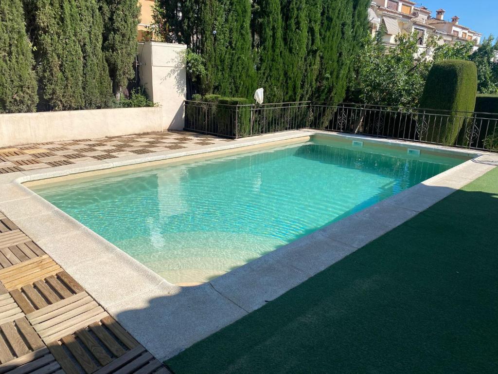 una piscina en un patio con 2 sillas en Villa Jazmín, en Monachil