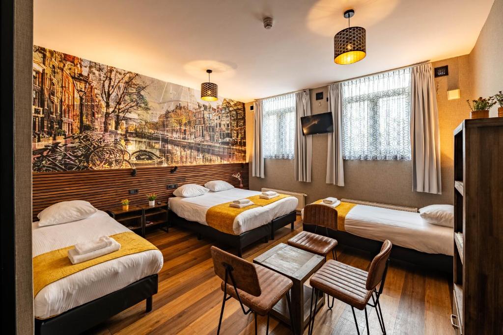 a hotel room with two beds and a table at Historic Centre Hotel in Amsterdam