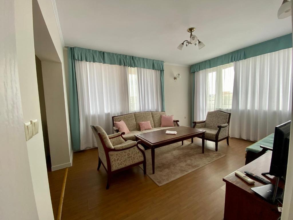 a living room with a couch and a table and chairs at Wild Cherry Apartments in Saints Constantine and Helena