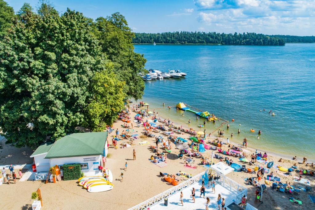 una multitud de personas en una playa cerca del agua en Klub Mila Kamień, en Ruciane-Nida
