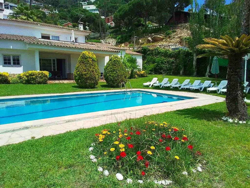 a swimming pool in the yard of a house at Villa Max in Lloret de Mar