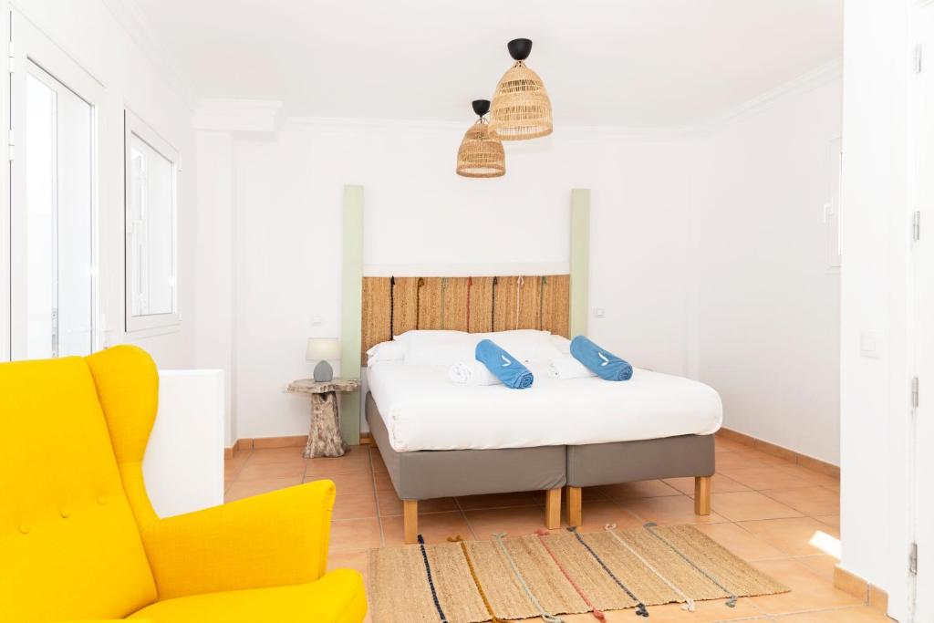 a bedroom with a bed and a yellow chair at Villa Veaco Beach with jacuzzi and private pool in Corralejo