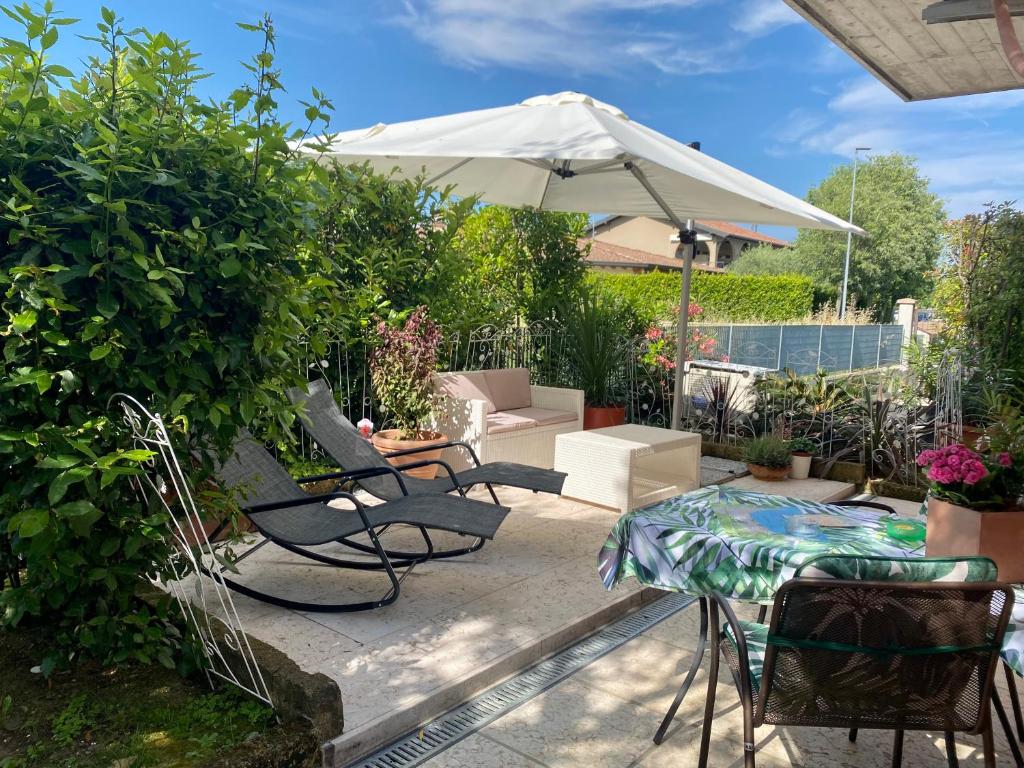 a patio with a table and chairs and an umbrella at B&B Garda 4U in Desenzano del Garda