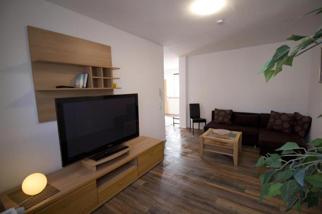 uma sala de estar com uma televisão de ecrã plano e um sofá em Liebevoll eingerichtete FeWo Alsfeld 2 em Alsfeld