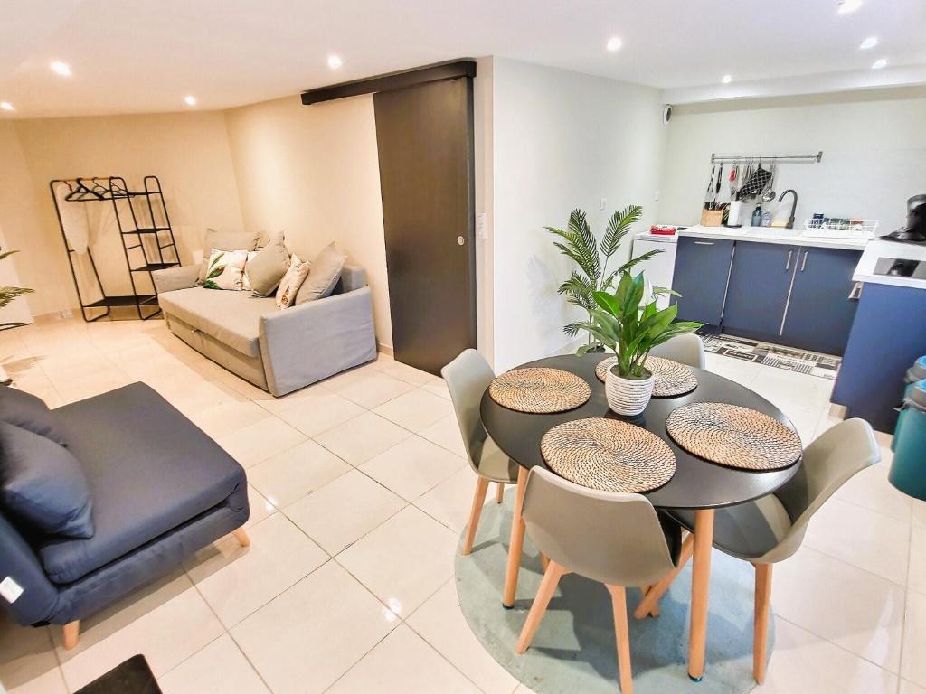 une cuisine et un salon avec une table et des chaises dans l'établissement Le Petit Rocher 30m2- Studio standing 3 étoiles, à Saint-Aignan-Grand-Lieu