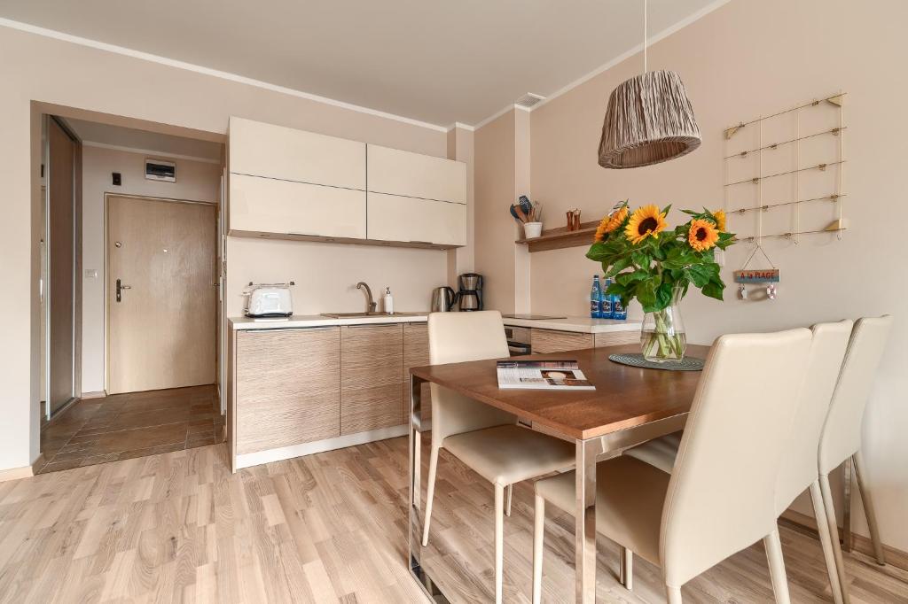 a kitchen and dining room with a wooden table and chairs at Your Holidays Pomorska in Międzyzdroje