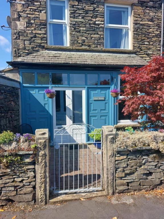 eine blaue Eingangstür eines Hauses mit einem Tor in der Unterkunft Ellerhow in Windermere