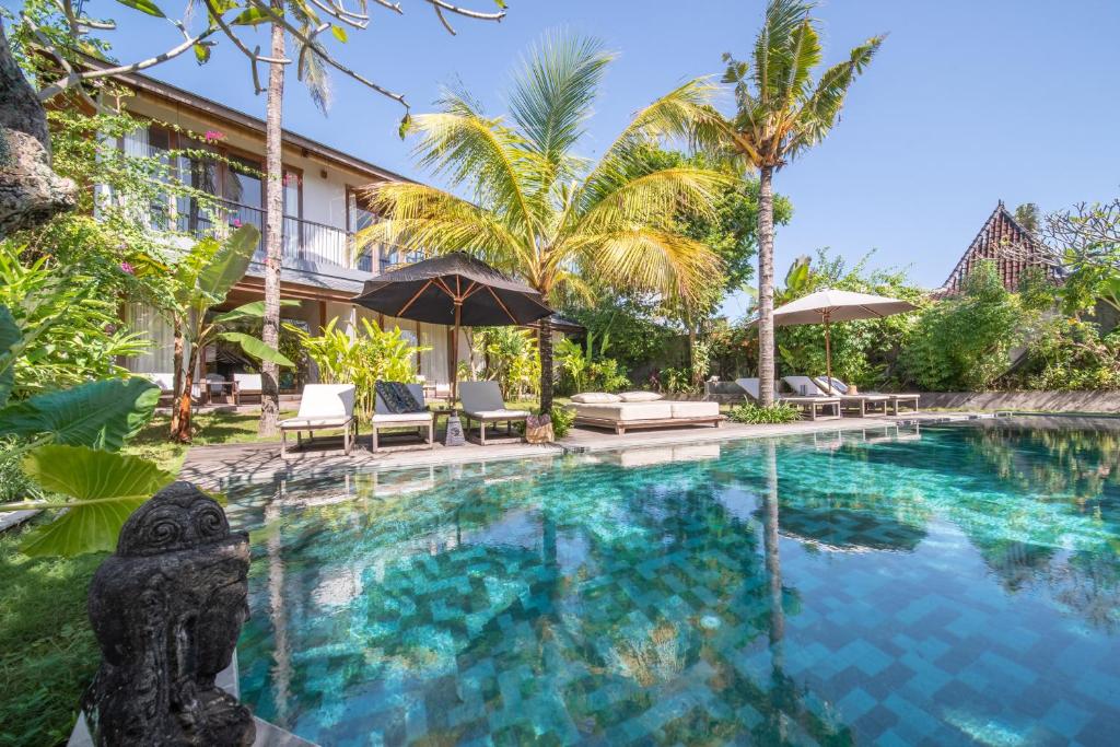 uma piscina num resort com palmeiras em MASMARA Resort Canggu em Canggu