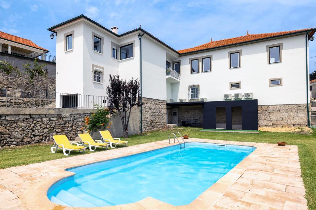 a villa with a swimming pool in front of a house at Casa do Desassossego in Monção