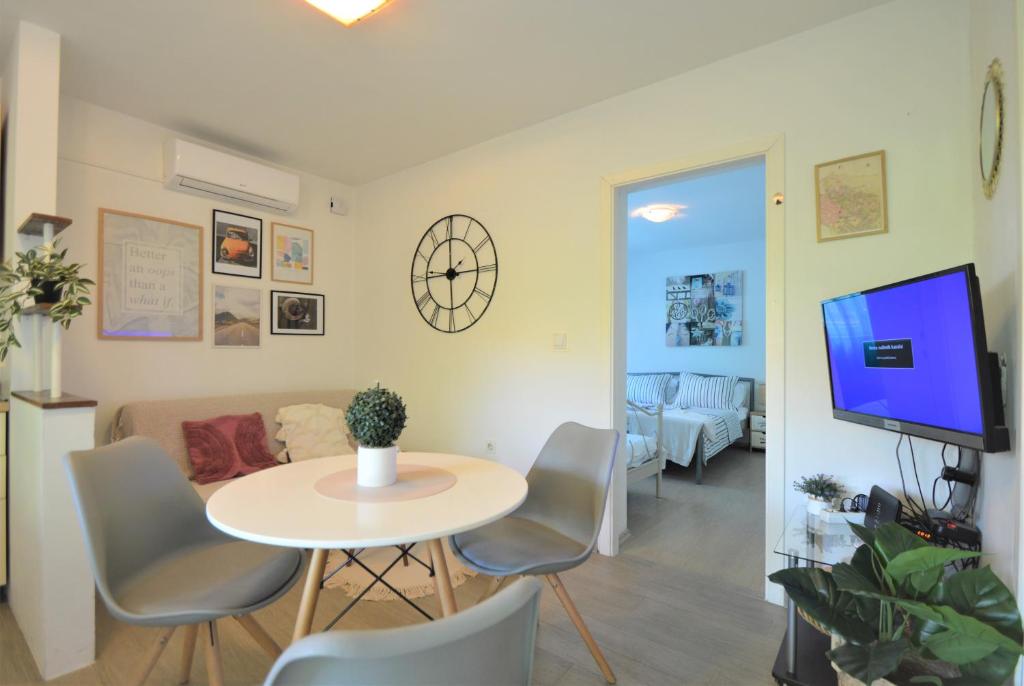- un salon avec une table, des chaises et une télévision dans l'établissement Apartment Vinea-parking included, à Šibenik