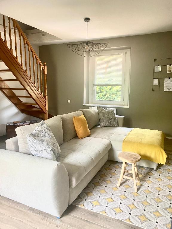 - un canapé blanc dans le salon avec un escalier dans l'établissement Superbe appartement duplex à Kaysersberg en Alsace, à Kaysersberg