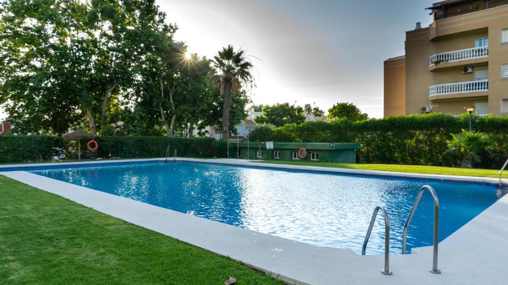 a swimming pool in a yard next to a building at Sun & Luxury at Guadalmar Beach in Málaga