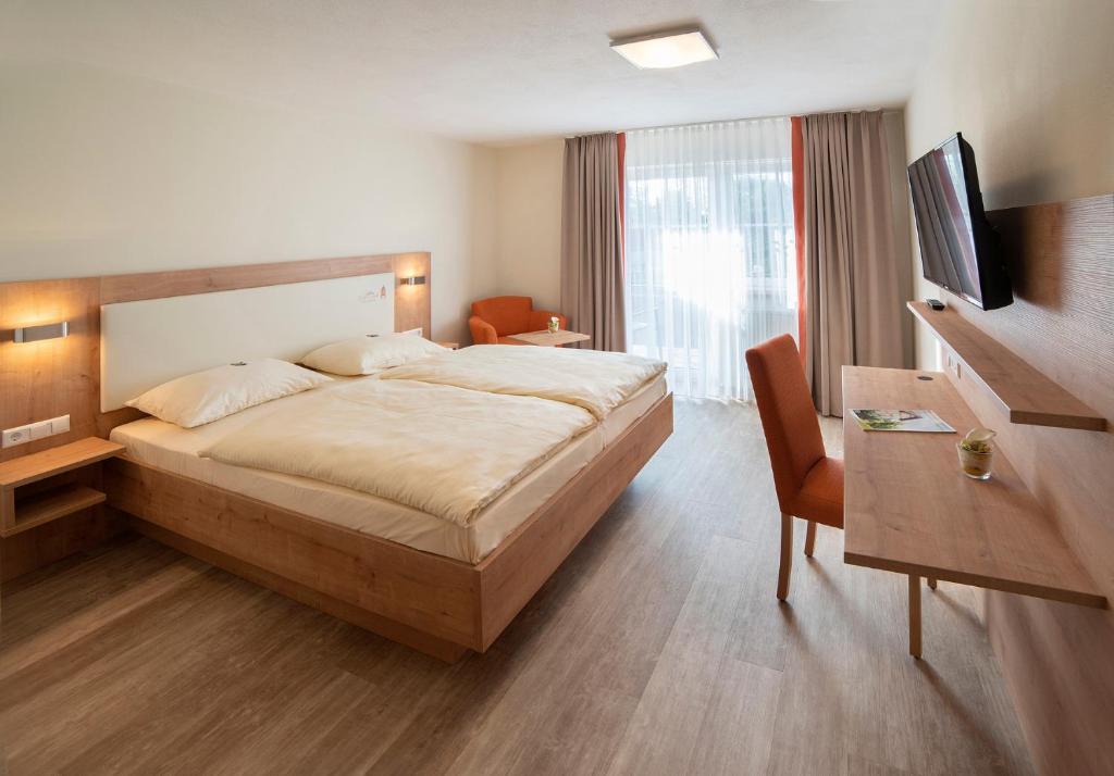 um quarto com uma cama grande e uma televisão em Gasthaus zum Stern em Gollhofen