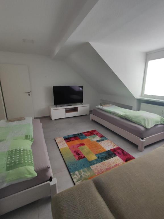 a living room with two beds and a flat screen tv at Joanna Apartment - MA City 2 in Mannheim