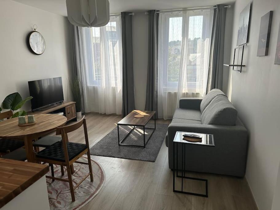 sala de estar con sofá y mesa en Appartement agréable et confortable pour 4 personnes, en Le Havre
