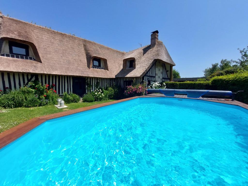 a large swimming pool in front of a house at Gîtes la Conterie in Fatouville-Grestain