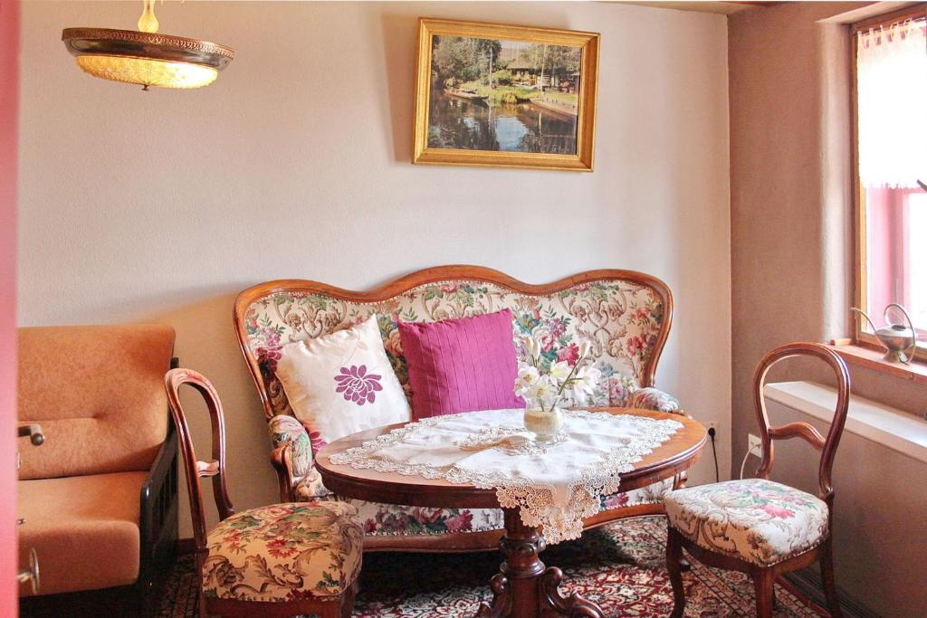 ein Wohnzimmer mit einem Sofa, einem Tisch und Stühlen in der Unterkunft Haus Zeitlos Ferienwohnung Zeitreise in Lübbenau