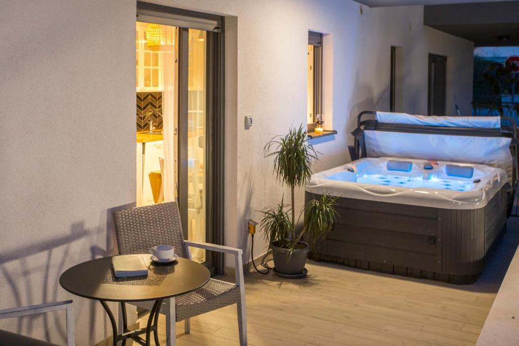 a room with a bed and a table and a tub at Studio and hot tub in Split