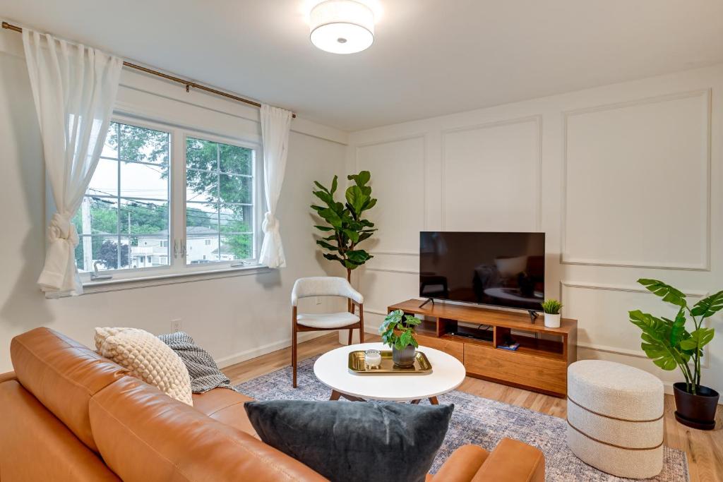 sala de estar con sofá y TV en Glen Cove Vacation Rental Less Than 1 Mi to Downtown!, en Glen Cove