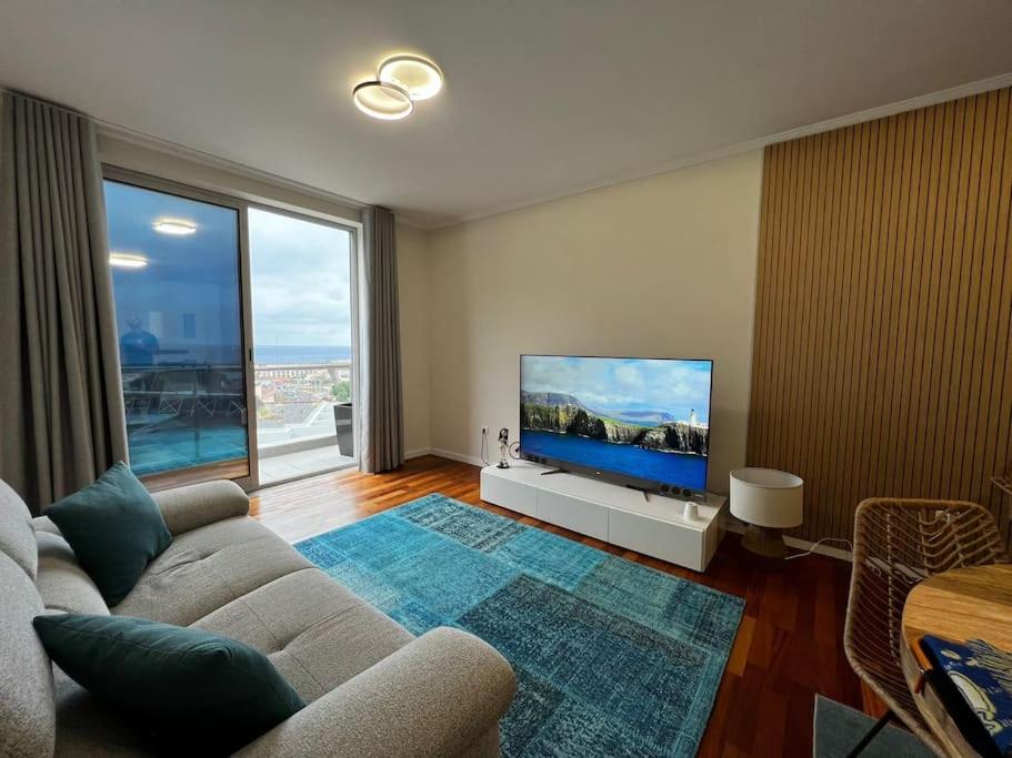 salon z kanapą i telewizorem z płaskim ekranem w obiekcie Ocean SC Apartment w mieście Santa Cruz