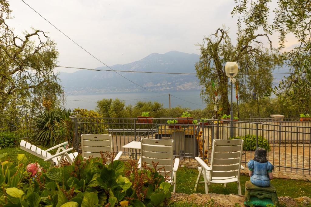einen Garten mit Stühlen, einem Tisch und einem Zaun in der Unterkunft Agricampeggio Paradiso in Brenzone sul Garda