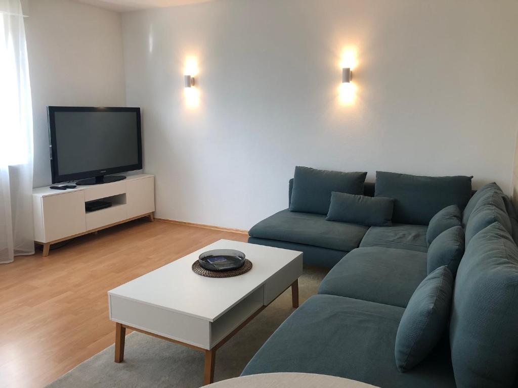a living room with a couch and a tv at Appartement Stuttgart Messe & Flughafen in Leinfelden-Echterdingen