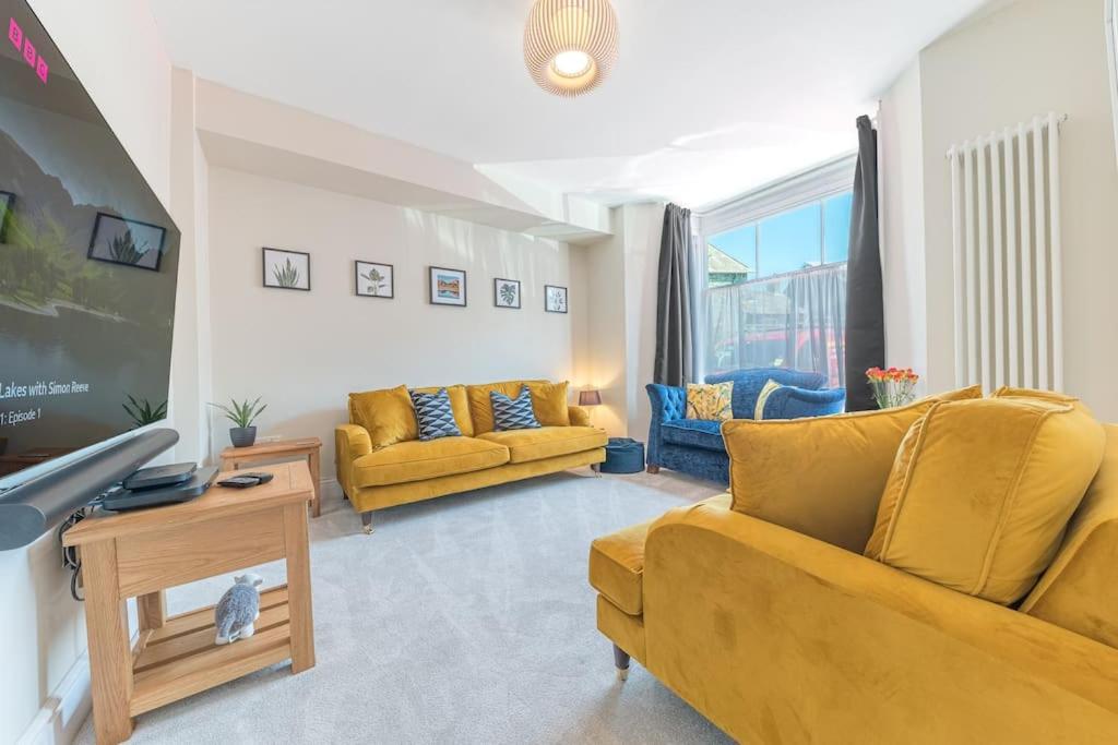 ein Wohnzimmer mit gelben Möbeln und einem gelben Sofa in der Unterkunft Hazelgrove, Ratcliffe Place, Keswick in Keswick