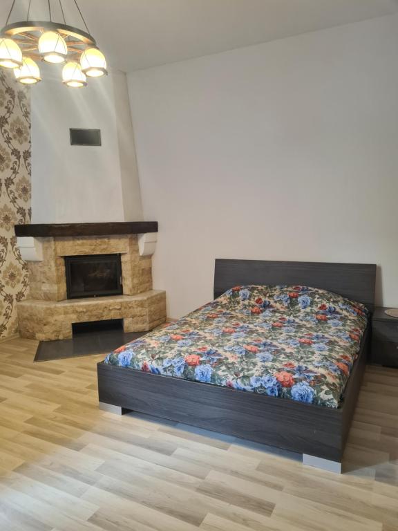 - une chambre avec un lit et une cheminée dans l'établissement Sonata, à Liepāja