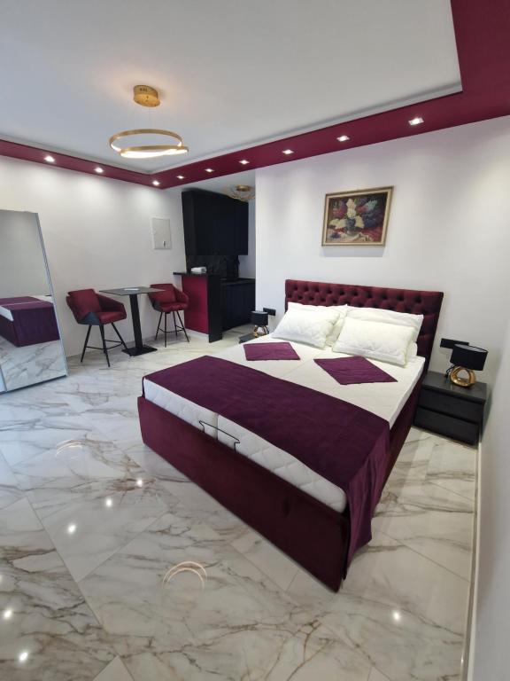 1 dormitorio con 1 cama grande, mesa y sillas en Victoria Apartments, en Makarska