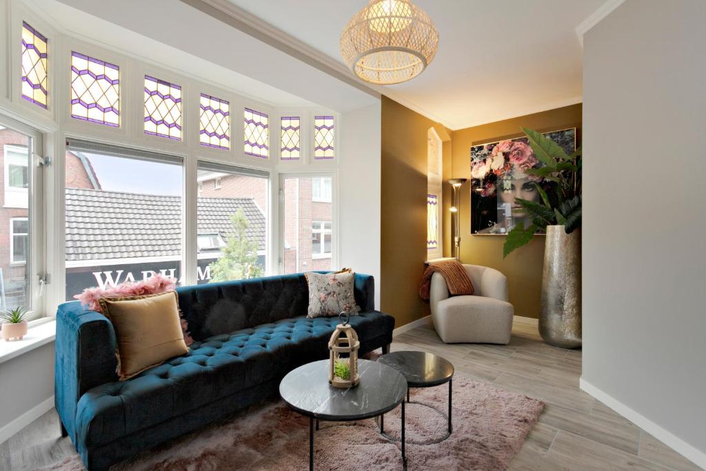 a living room with a blue couch and a table at 17, EnschedeCentrum in Enschede