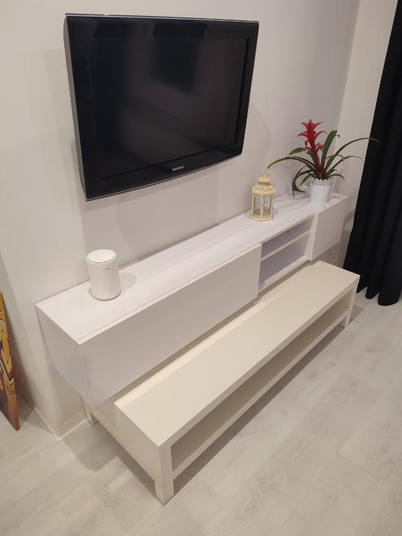 a white entertainment center with a flat screen tv on a wall at Apartament Sopot centrum in Sopot