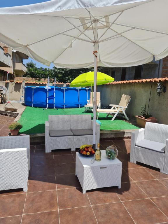 une terrasse avec un parasol blanc, des chaises et une table dans l'établissement Casa Peppuccio, 