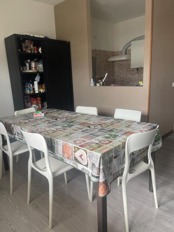 a dining room table with white chairs around it at Albergo Civico 7 in Leno